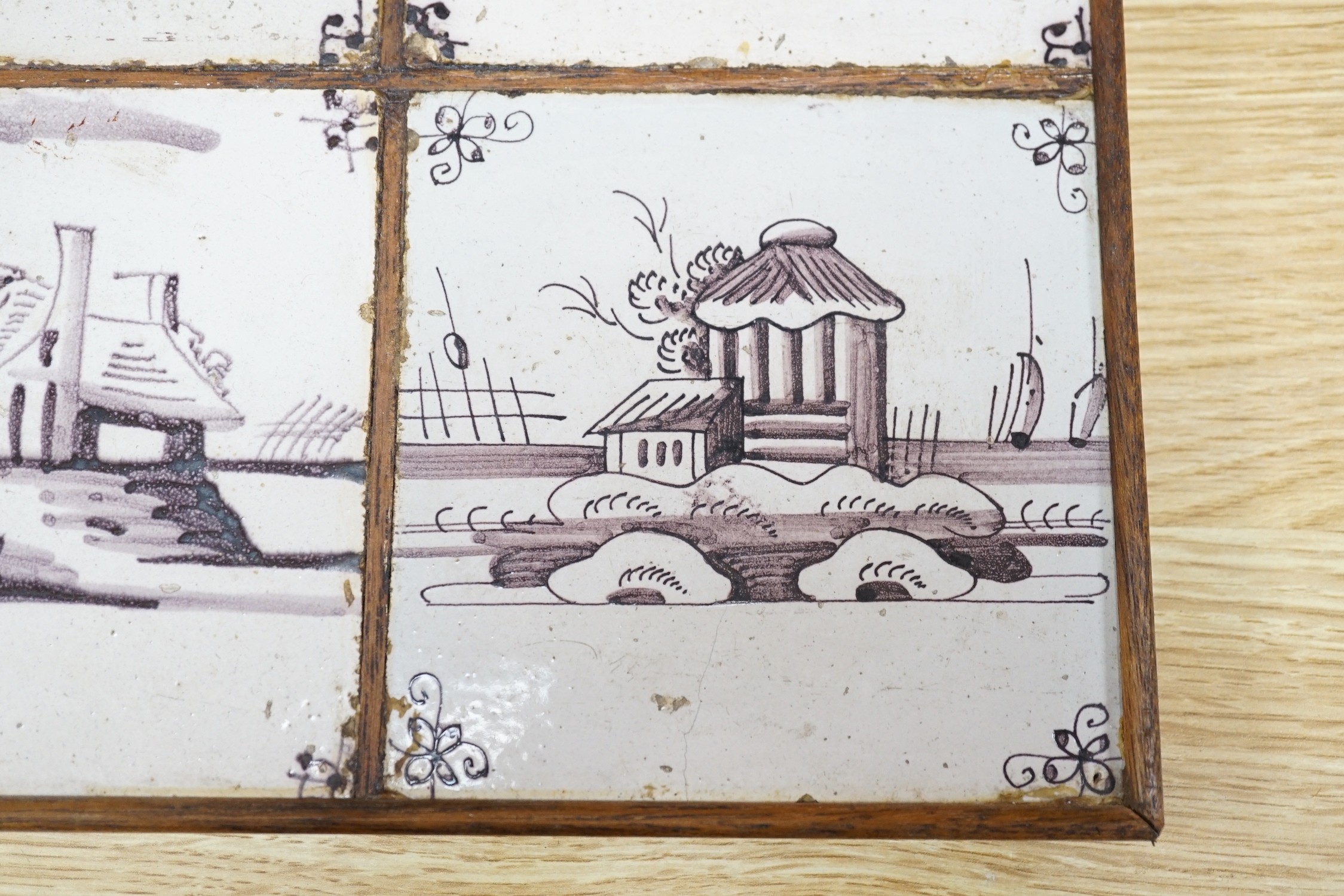 A set of four 18th century Dutch Delft manganese tiles decorated with buildings by a canal (frame 27cm)